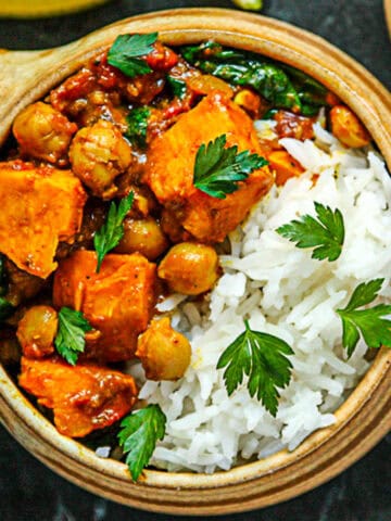 Sweet potato chickpea curry and rice in a pottery bowl.