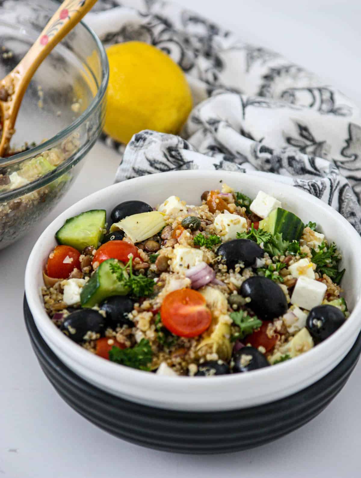 Quinoa and lentil salad in a black and white bowl.