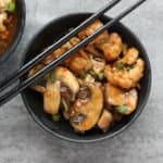 A bowl of food, with mushrooms and Cauliflower