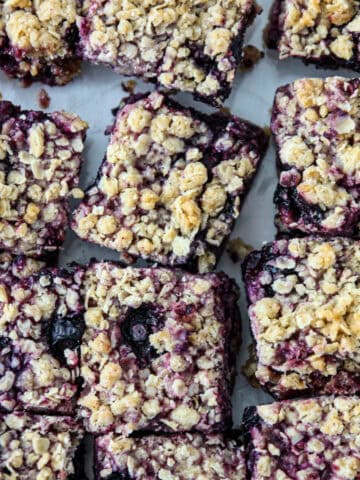 A batch of blueberry oatmeal bars on parchment paper.