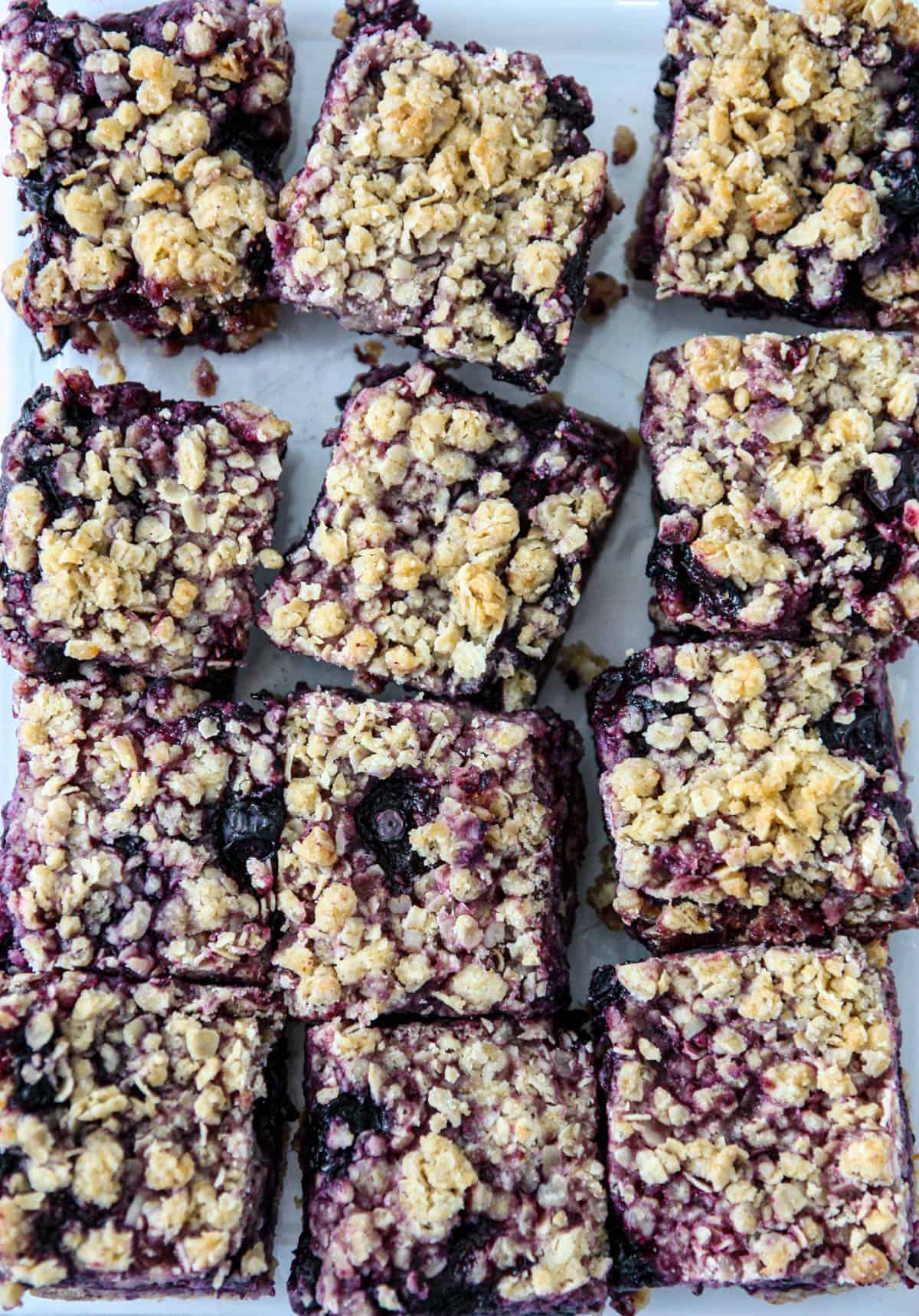 A freshly baked batch of blueberry oatmeal bars on parchment paper.