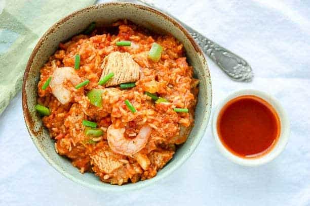 A close up of food in a bow, with shrimp and rice