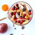 A jug of sangria on a table, with fruit