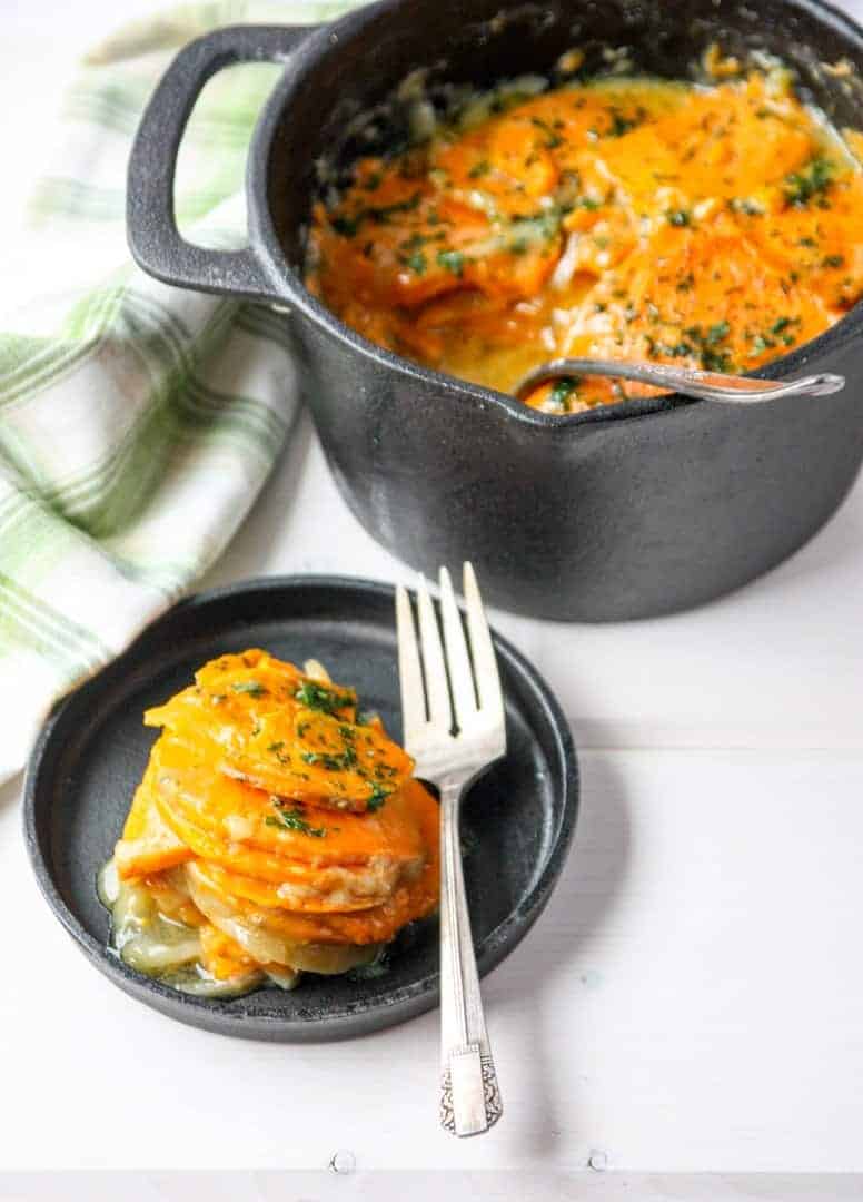 A pot of sweet potatoes, with a plate of sweet potatoes and a fork