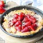 Top shot of strawberry Dutch baby gluten free in cast iron skillet.
