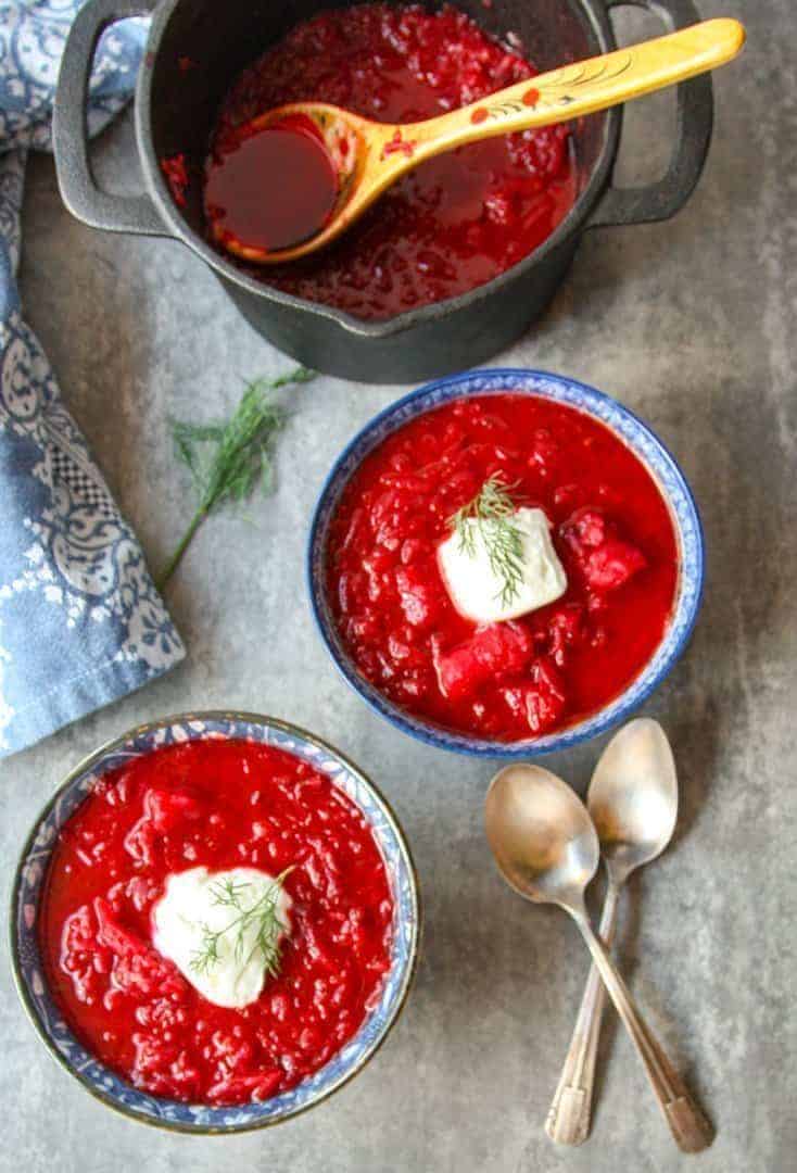 black pot and two blue and white bowls filled with Ukrainian borscht 