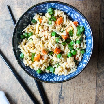 A bowl of food with rice and broccoli