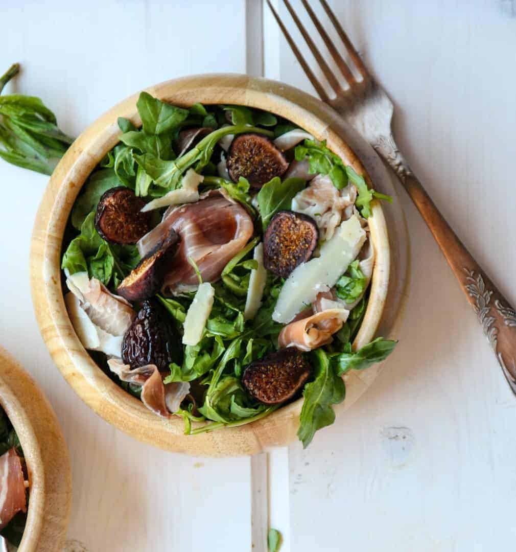 A bowl of salad and a fork on a table