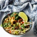 A bowl of soup with mushrooms, bean sprouts and noodles