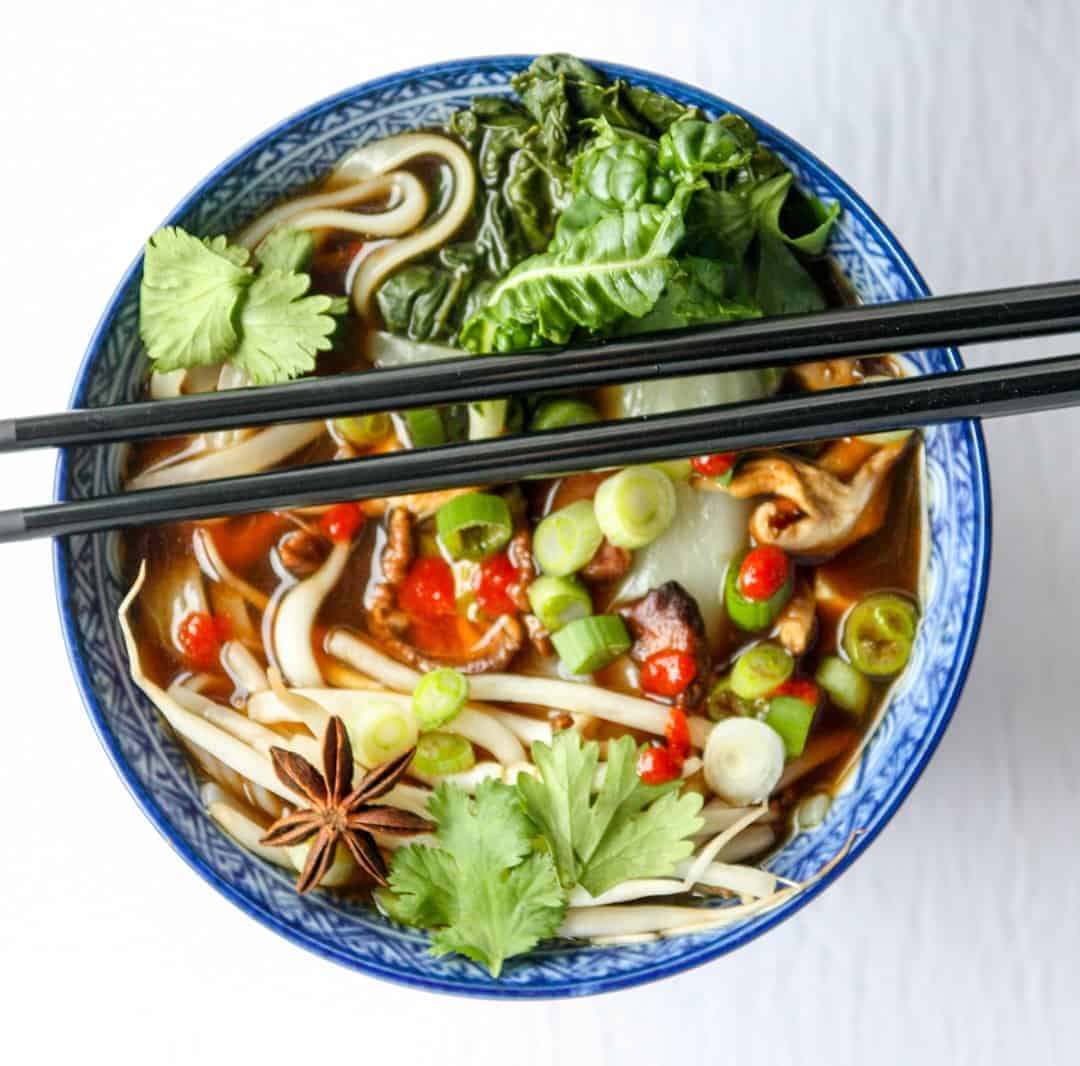 top shot of pho in bowl with black chopsticks laying on top
