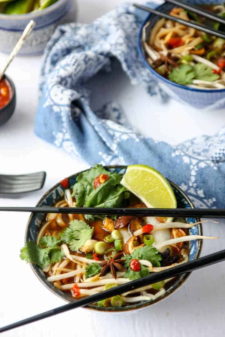 top shot of Vietnamese soup in bowl next with black chopsticks