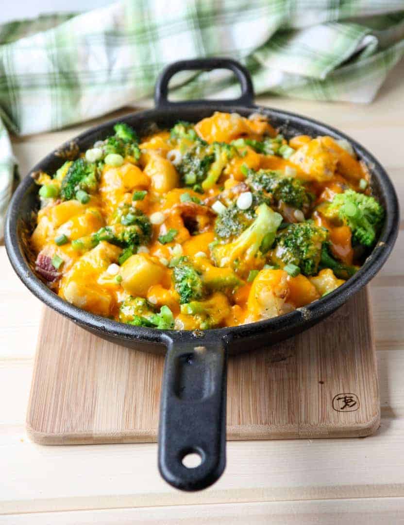 A skillet of food on a cutting board.
