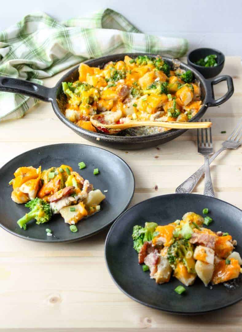 Two plates of food on a table with forks.