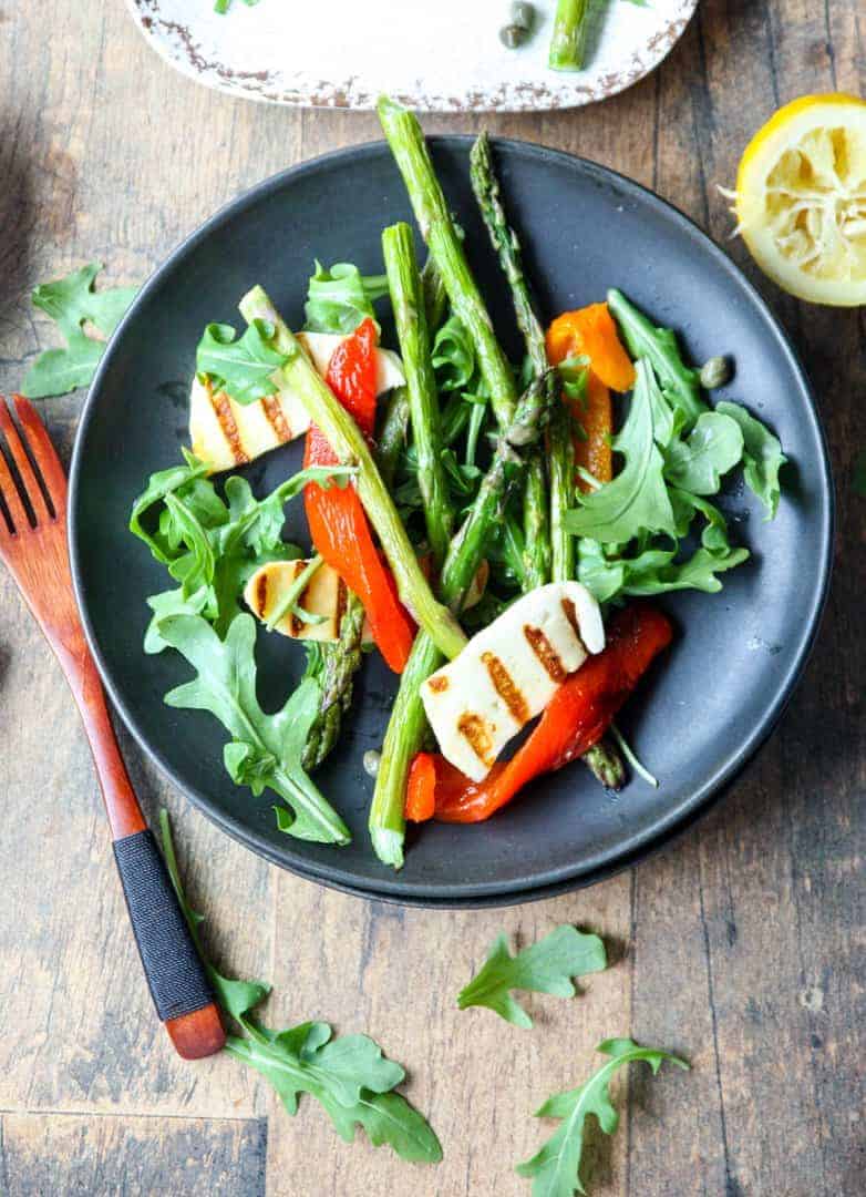 A bowl of salad on a plate, with Halloumi and Cheese