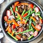 Steak & Asparagus Stir Fry with Red Pepper and Mushrooms in a cast iron pan