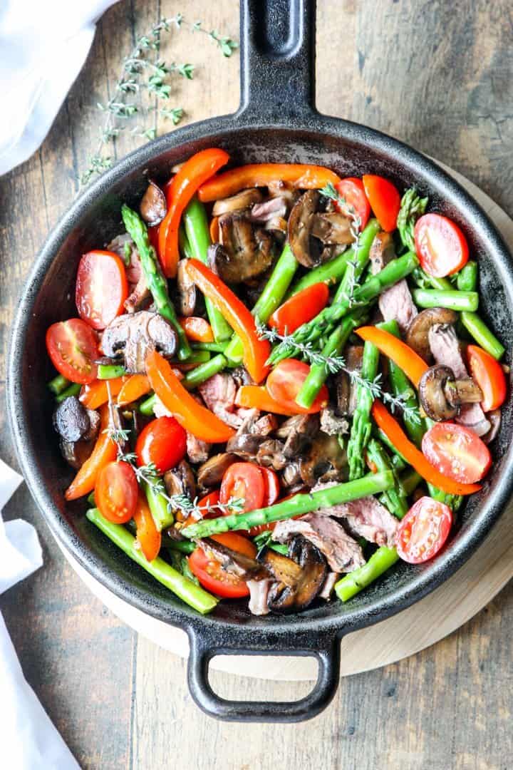 Steak & Asparagus Stir Fry with Red Pepper and Mushrooms in a cast iron pan
