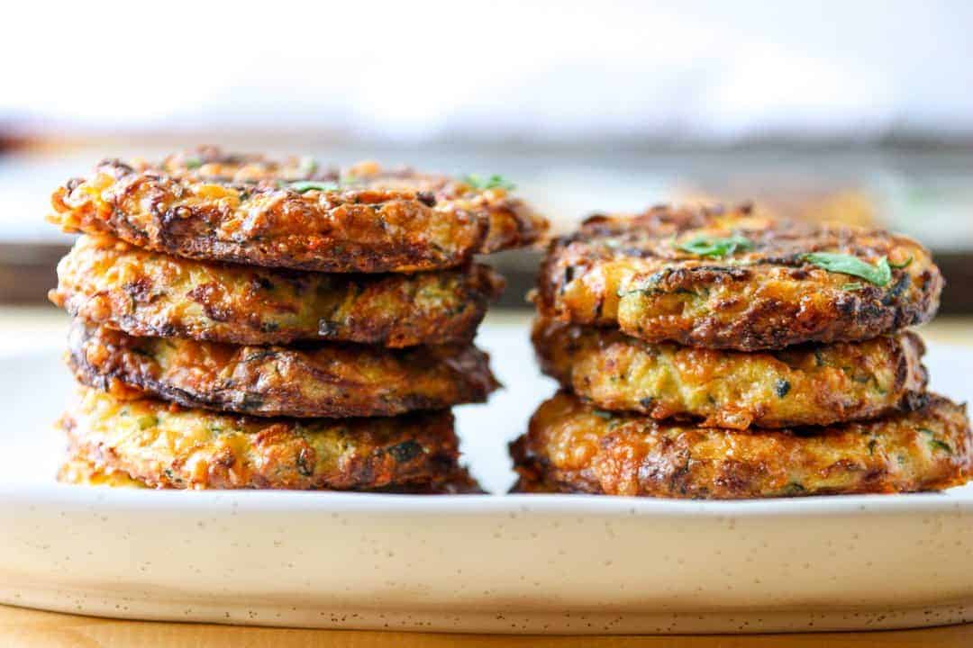 Two stacks of baked zucchini fritters on a plate
