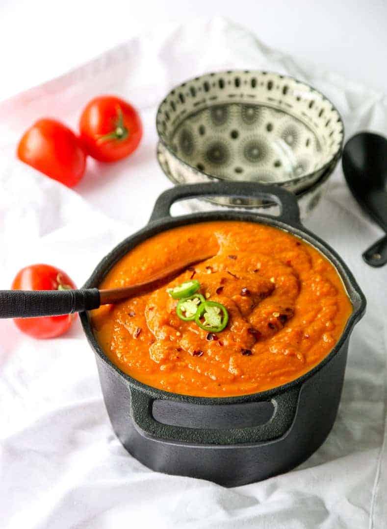 A pot of southwestern pumpkin soup with two bowl ready to be filled.