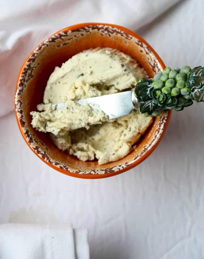 Goat cheese in bowl, with a cheese spreader