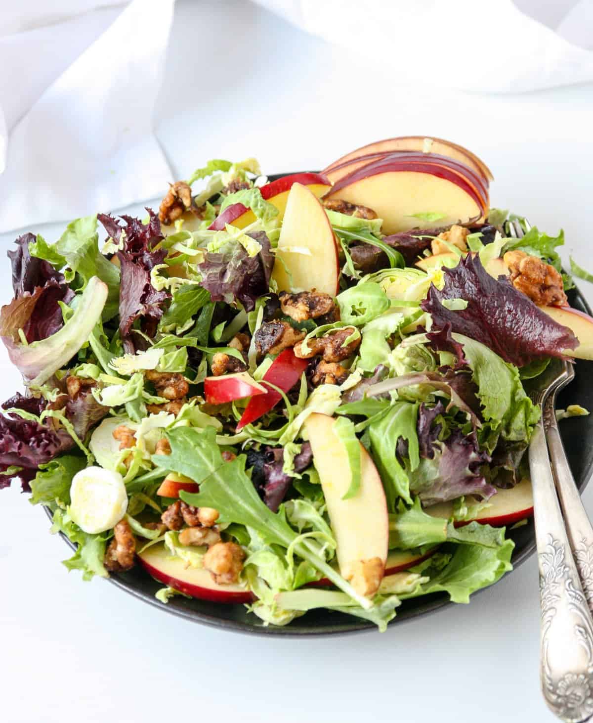 A close up of apple and brussels sprout salad on a plate.