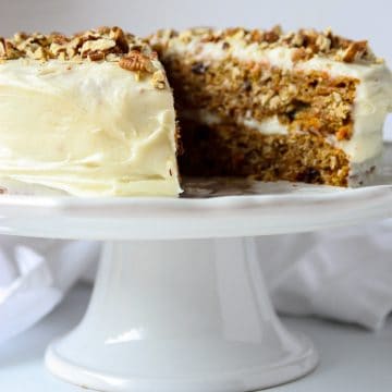 Gluten-Free Carrot Cake with cream cheese frosting on a cake stand.