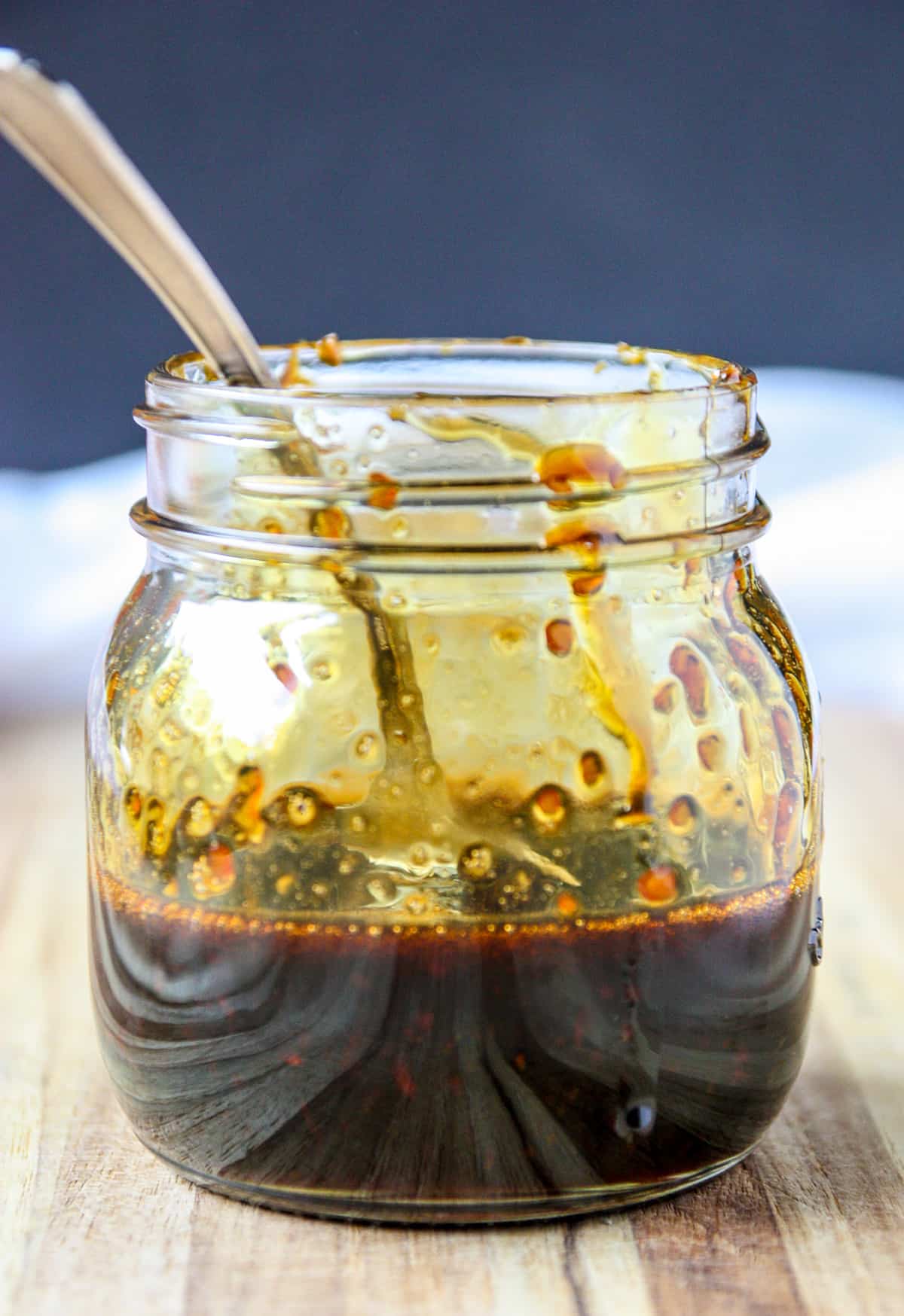 A glass jar half full of  sauce.