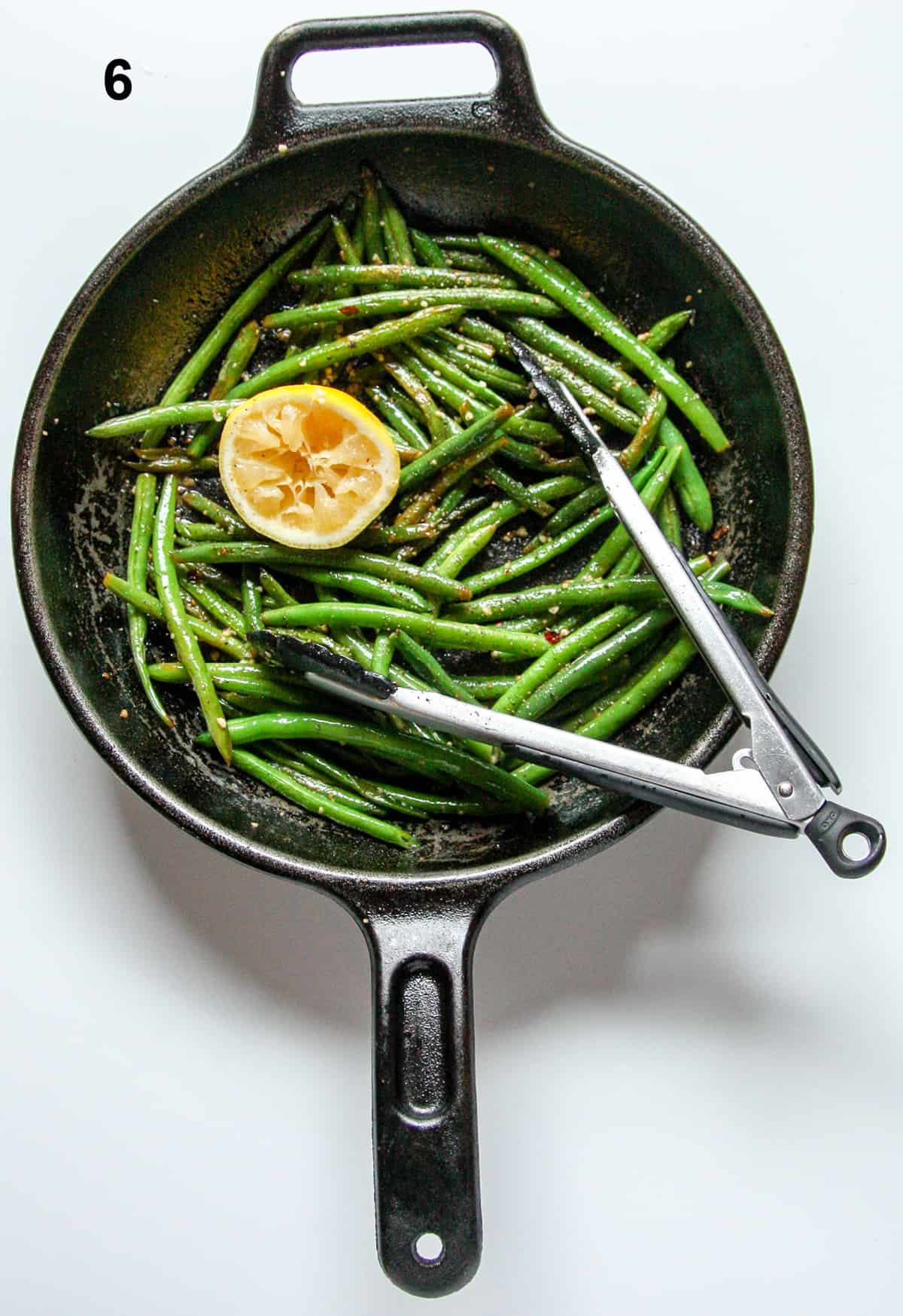 A pan of green beans with a lemon.