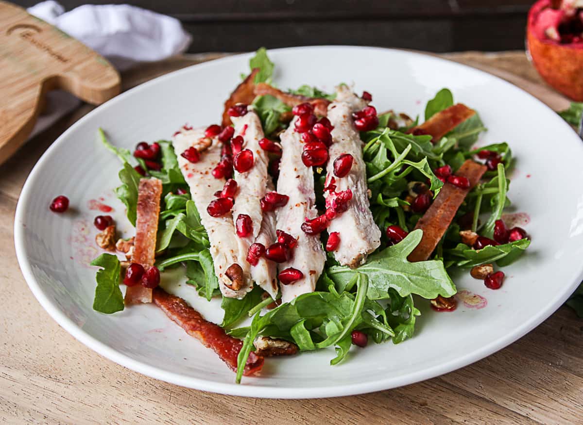 Turkey club salad on a white plate.