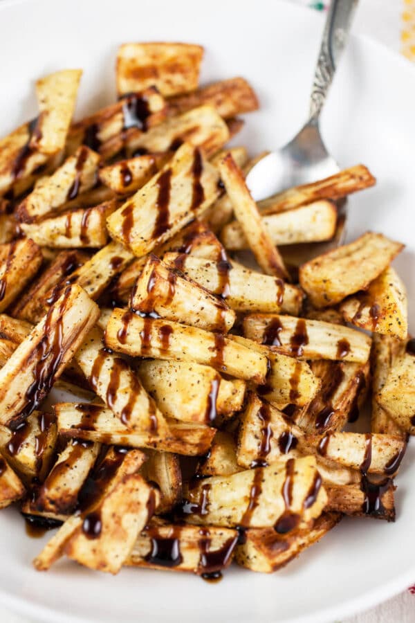 Air fried parsnip fries in a white dish.
