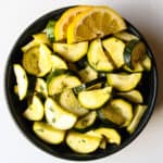 Air fried zucchini slices in a black bowl.