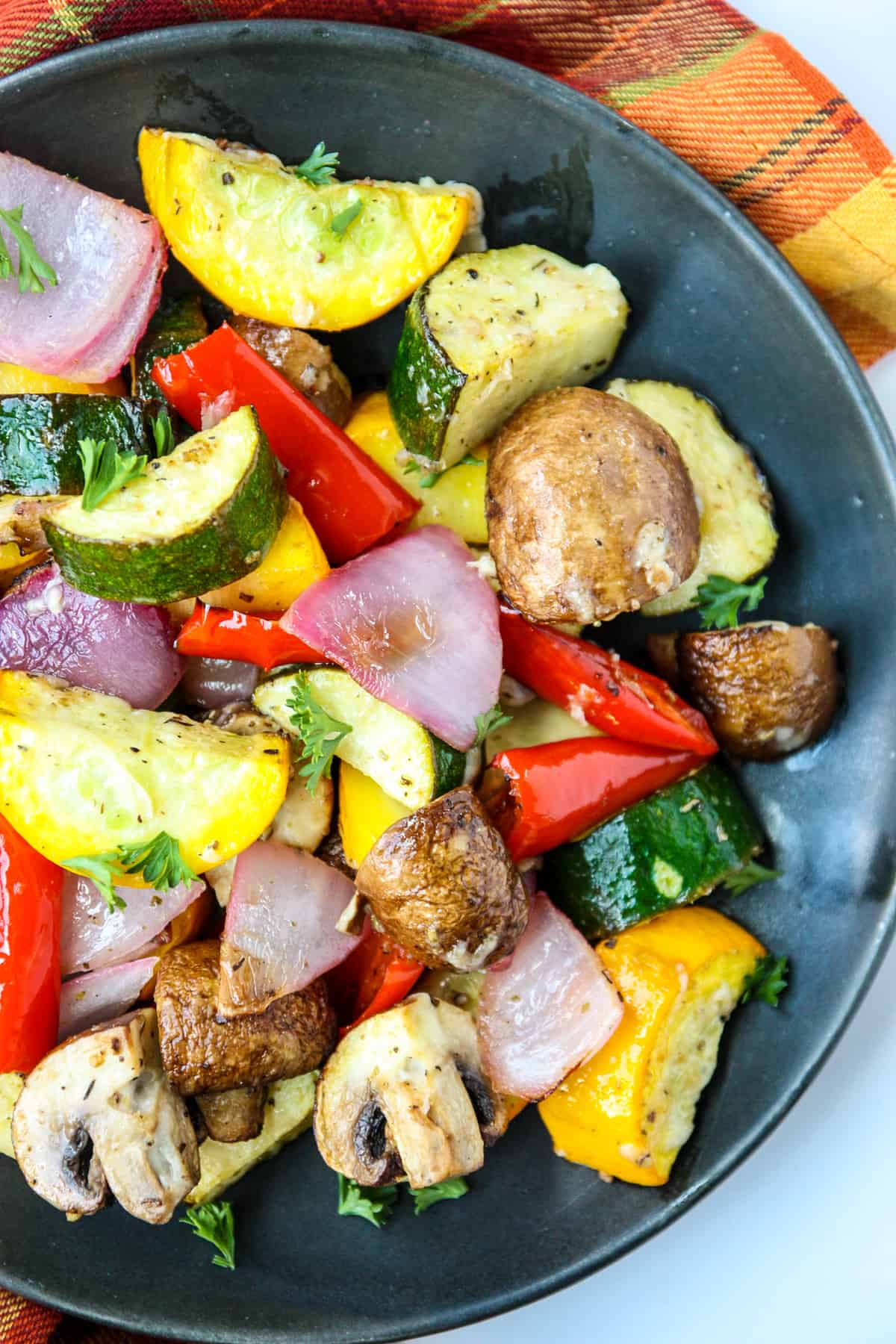 Air fryer roasted vegetables on a black plate.