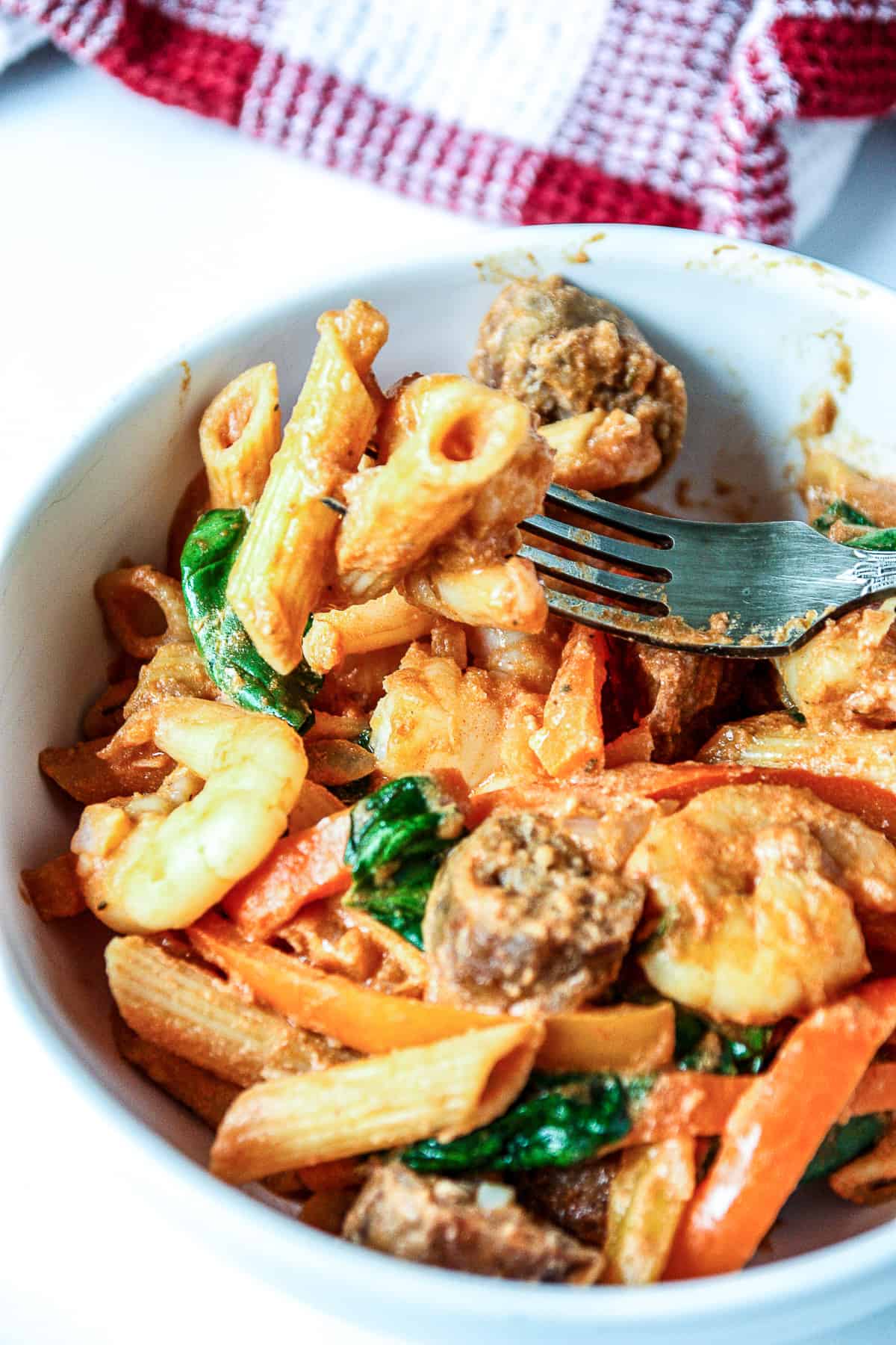 A forkfull of creamy cajun shrimp and sausage pasta.