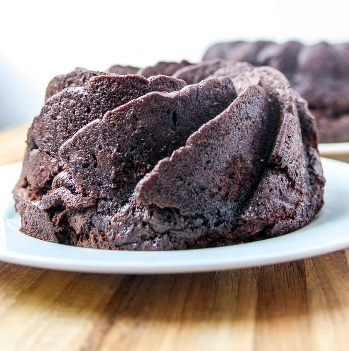 The baked cake cooling on a plate after being removed from the pan.