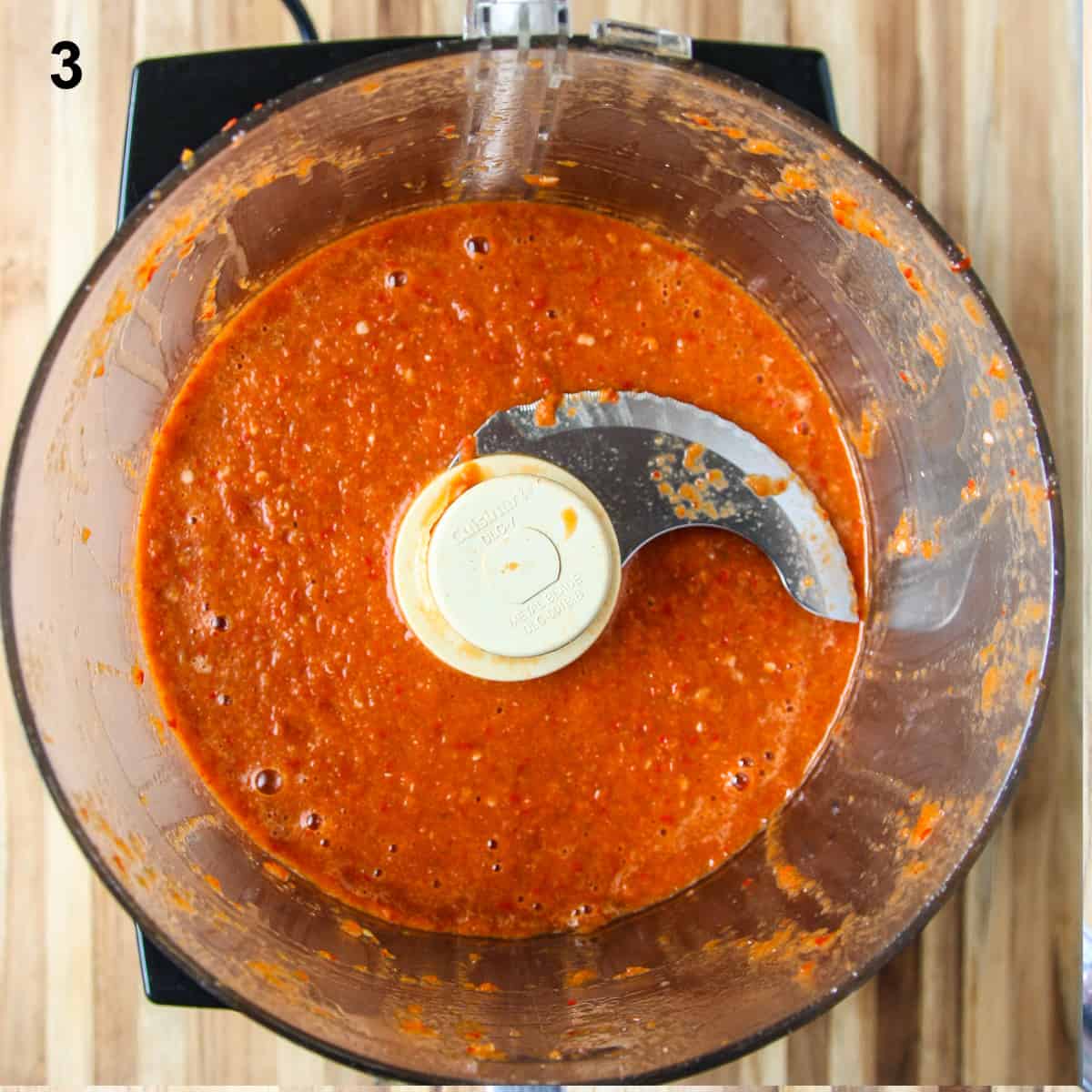 The cooked sauce in the food processor   bowl after being processed to a smooth consistency.