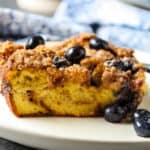 A slice of blueberry brioche French toast casserole on a white plate.