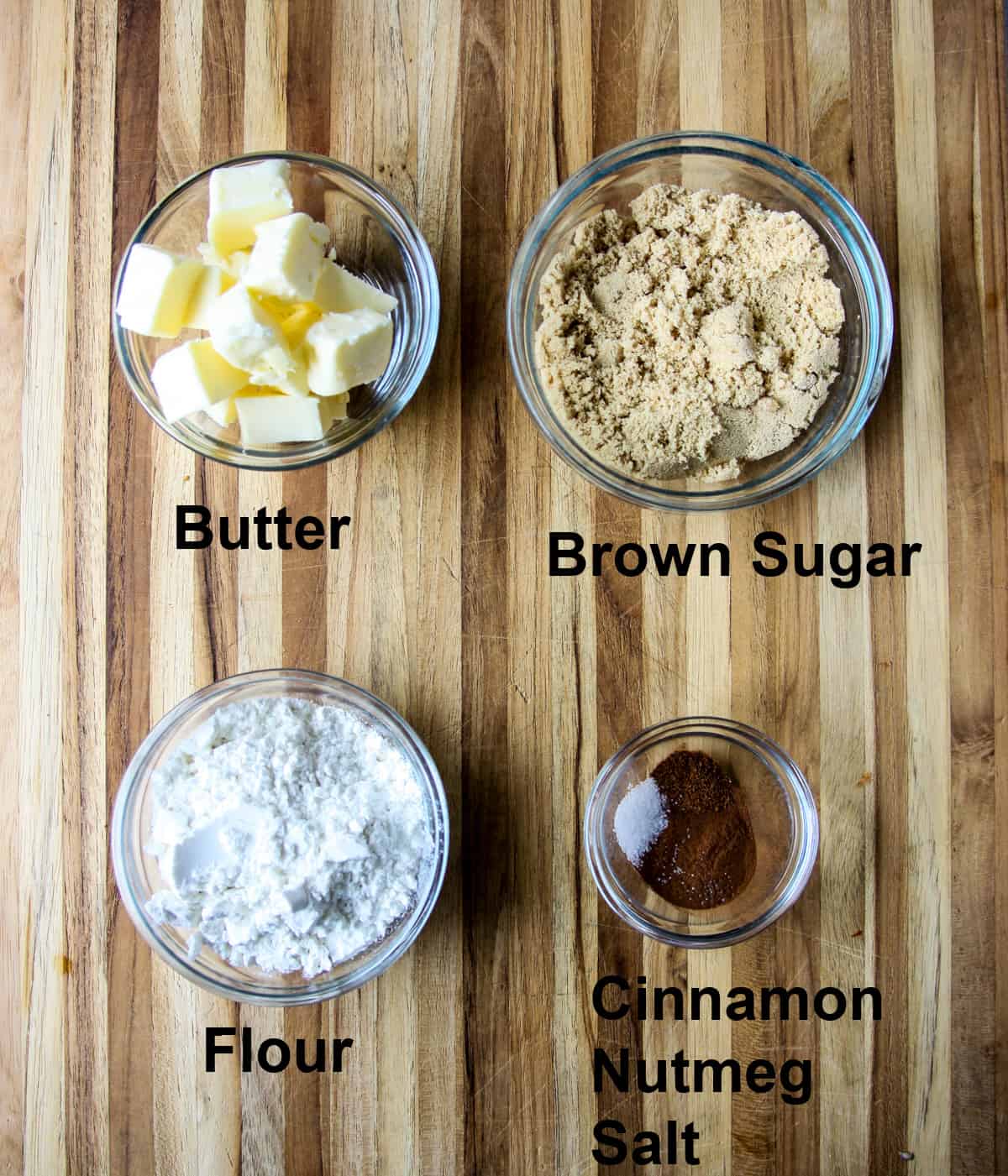 The ingredients for making the streusel topping for French toast casserole, in glass dishes on a wooden board.