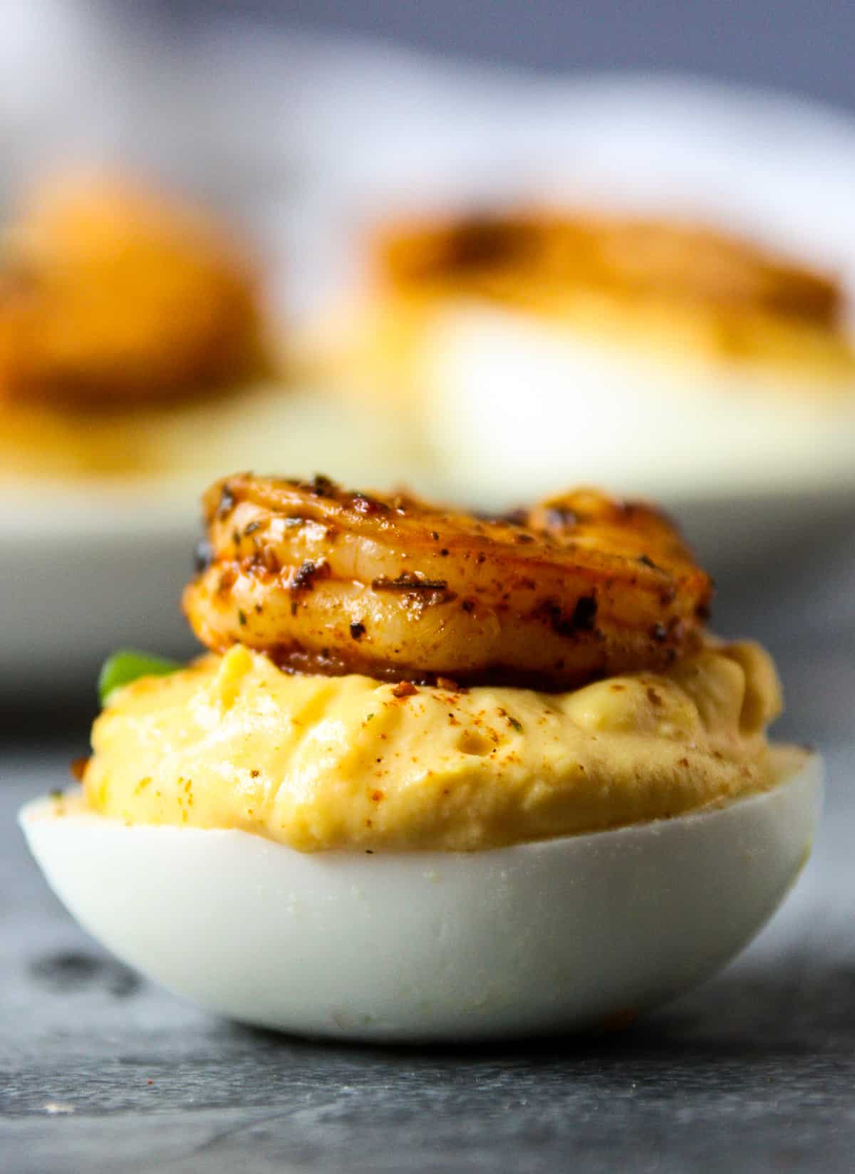 A deviled egg topped with a Cajun seasoned shrimp.