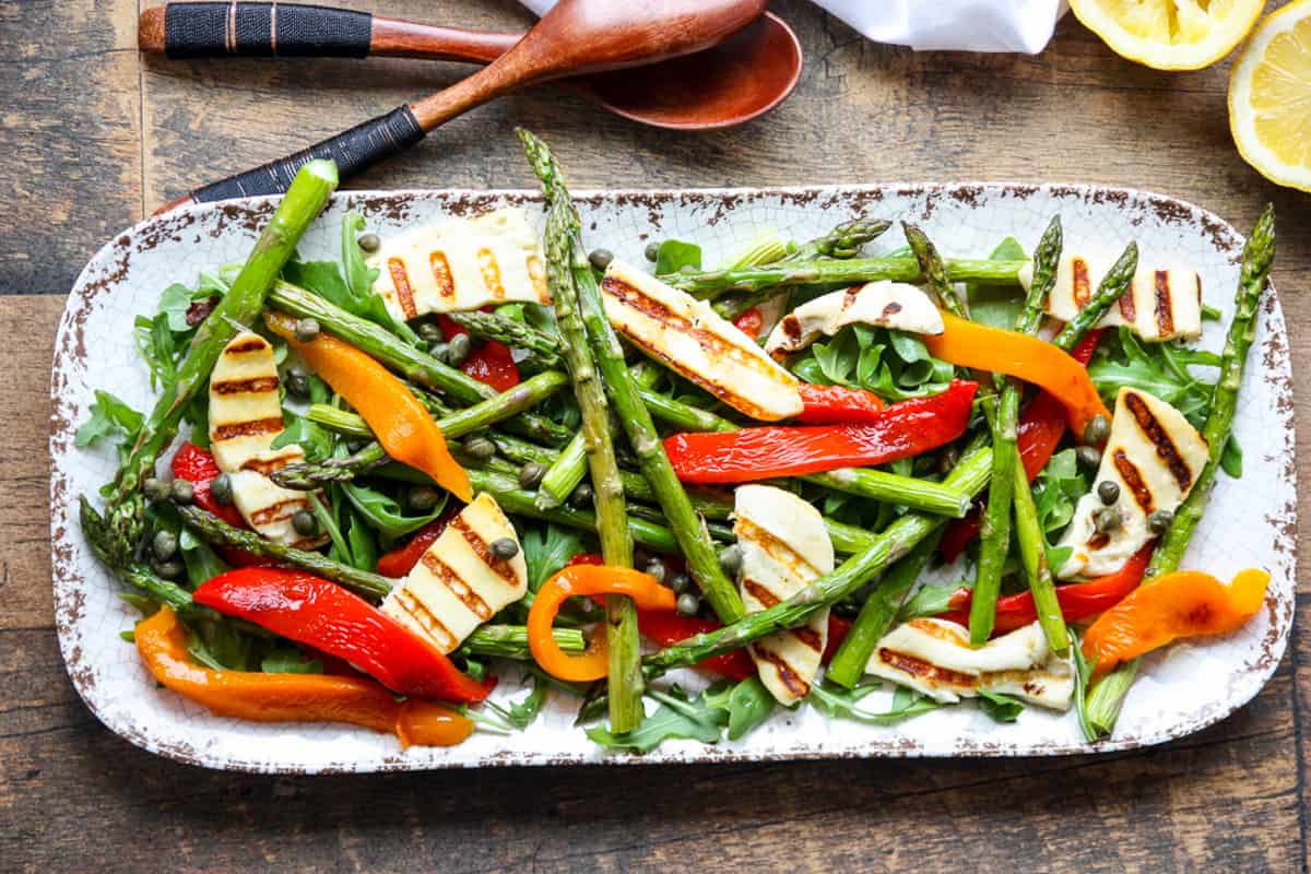 Asparagus and halloumi salad on a white platter.