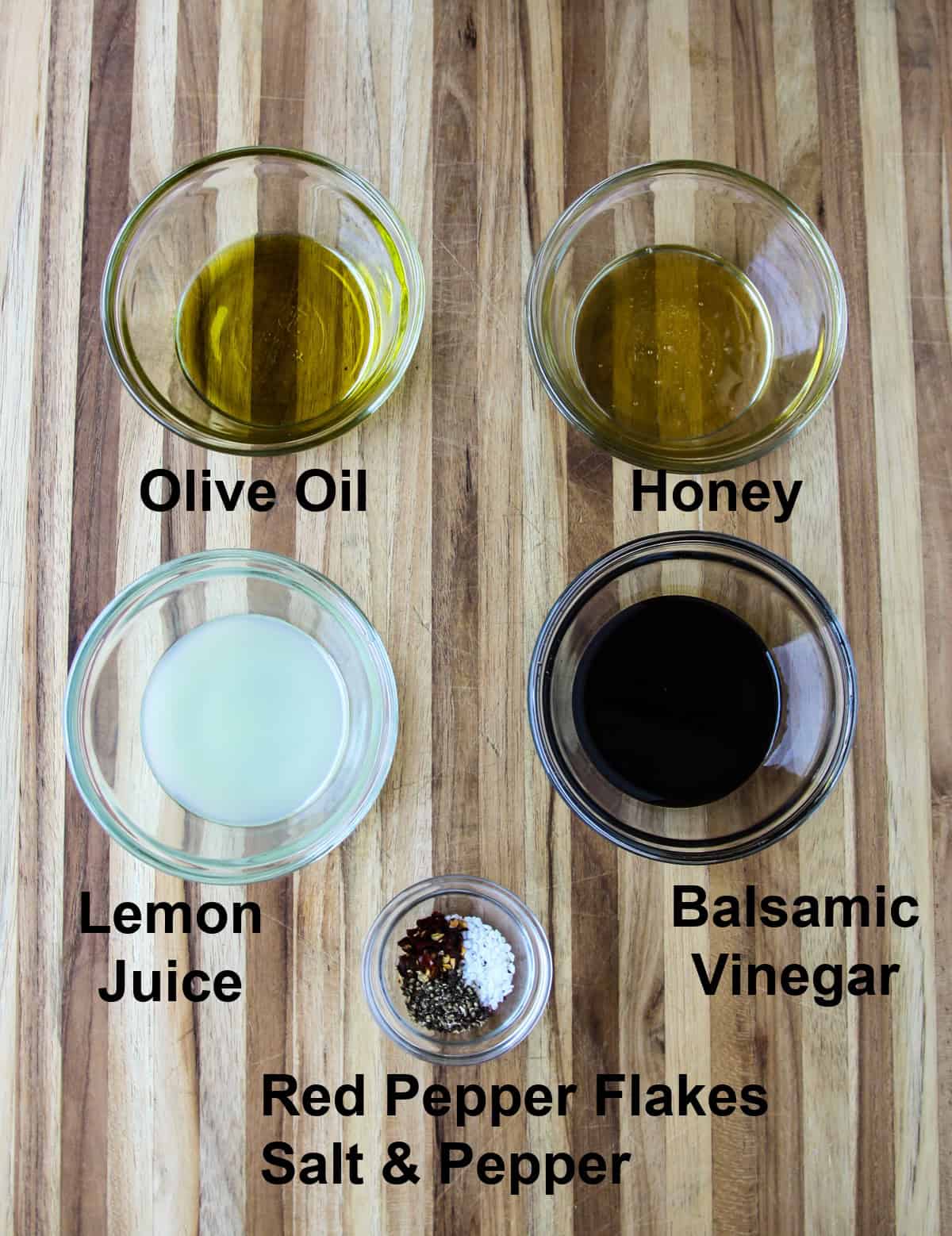 The ingredients needed to make the salad dressing in glass bowls.