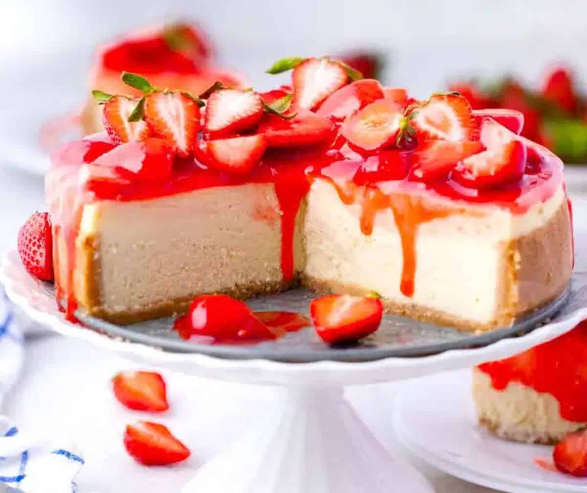 A strawberry cheesecake with a slice removed.