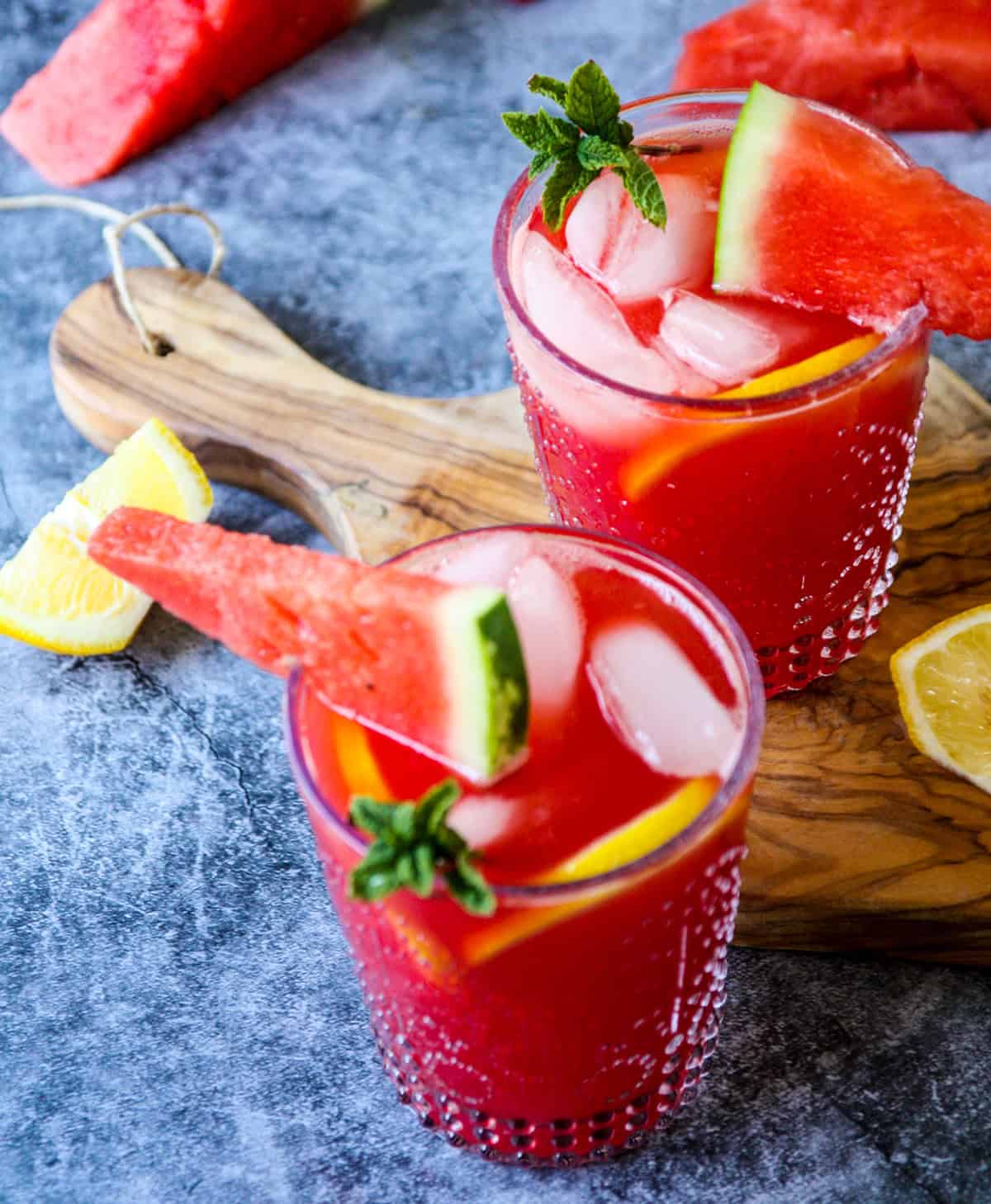 Two vodka watermelon cocktails garnished with mint and watermelon wedges.