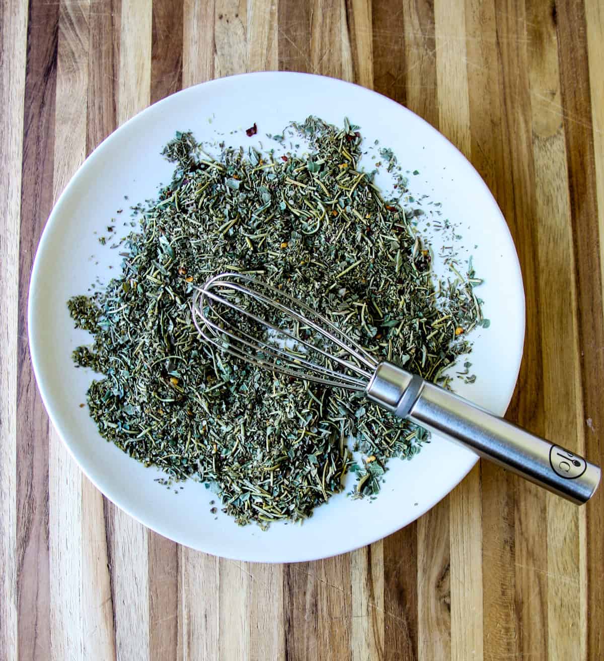 The herbs being combined with a whisk.
