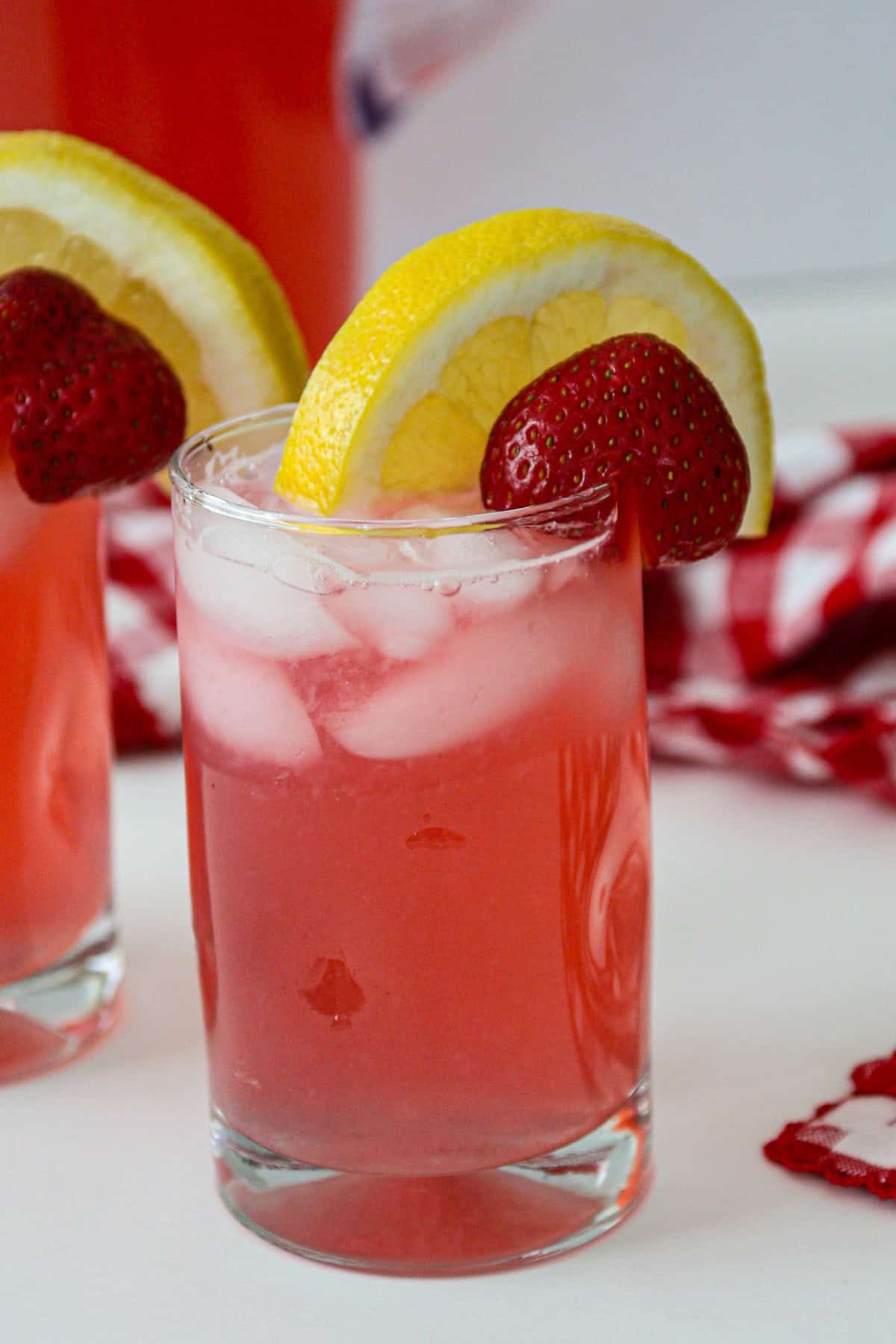 A glass of rhubarb lemonade topped with a slice of lemon.